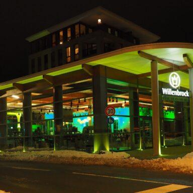 Die Weinhandlung Willenbrock in Lingen beleuchtet bei Nacht am Tag der Kinderhospizarbeit