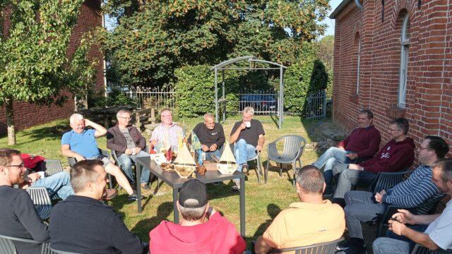 Die Teilnehmenden am Väterwochenende von Löwenherz unterhalten sich draußen im Sitzkreis