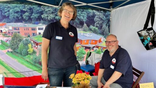 Ehrenamt bei Löwenherz: Zwei Ehrenamtliche betreuen einen Infostand