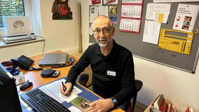 Der Löwenherz-Ehrenamtliche Bernhard Wienand sitzt am Computer im Büro.