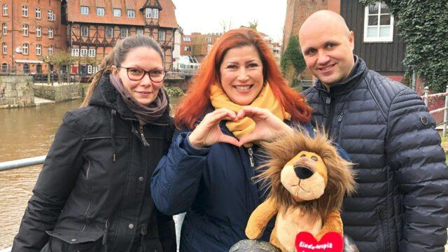 Das Lüneburger Löwenherz-Team steht mit Maskottchen am Fluss