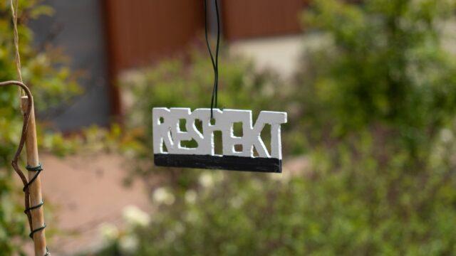Das Wort Respekt hängt als Holzschnitt im Kinderhospiz-Garten an einem Draht