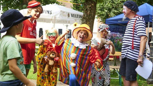 5 Kinder und eine erwachsene Person als Clown verkleidet.