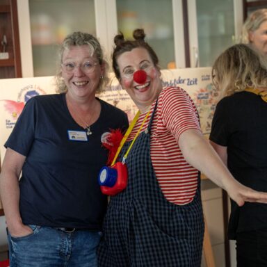 Eine Clownin posiert mit Löwenherz-Mitarbeiterin Sabine Dirkes.