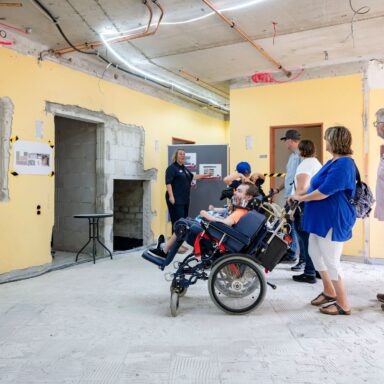 Eine Familie mit einem Jungen im Rollstuhl schaut sich die Baustelle im Kinderhospiz Löwenherz an