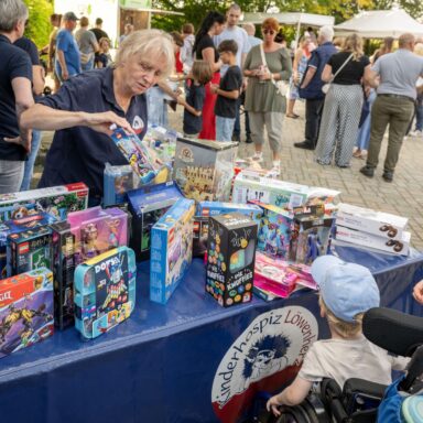 Eine Löwenherz-Ehrenamtliche steht an einem Tisch mit Spielsachen.
