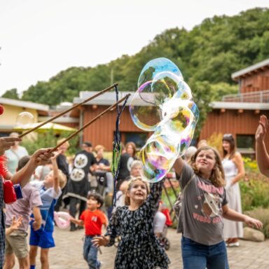 Eine Clownin macht große Seifenblasen