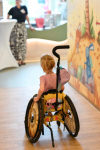 Ein kleinen Mädchen im Rollstuhl von im hinten im Flur von Kinderhospiz Löwenherz